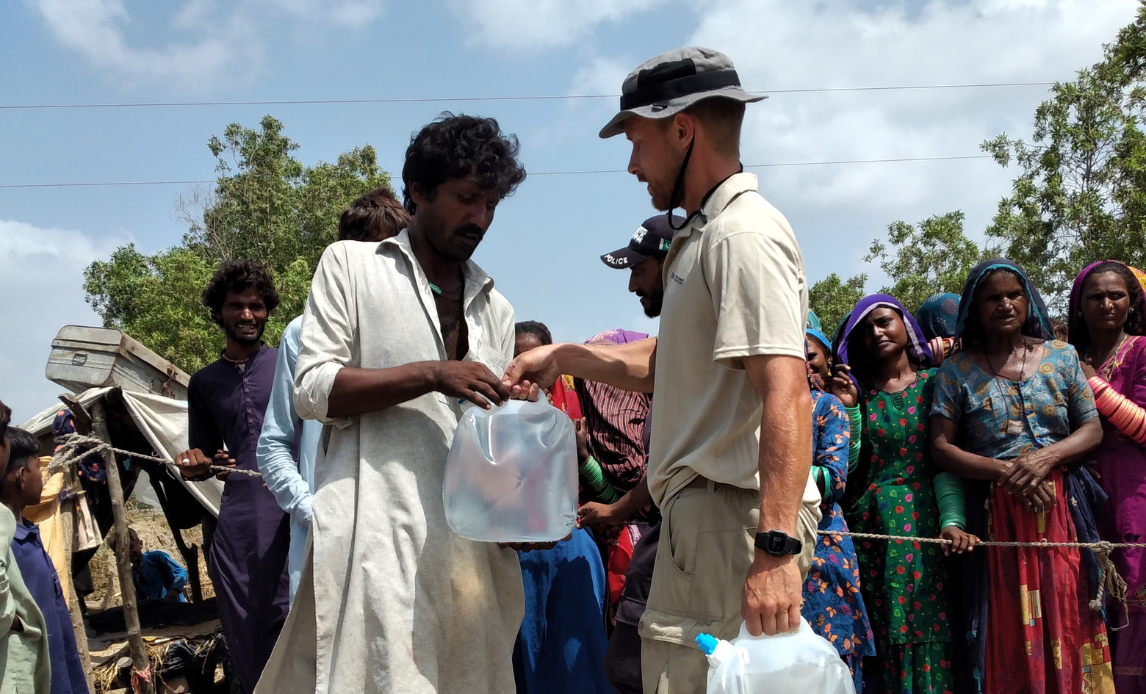 Internationale eksperter i det nordiske beredskabssamarbejde uddeler rent vand til pakistanske borgere.