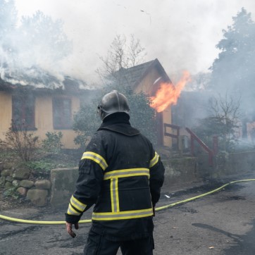 brandmand foran brændende hus
